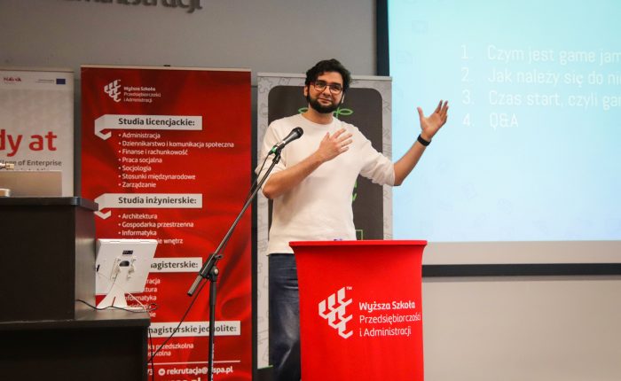 Patryk Gałach przed mikrofonem - prelegent konferencji "Kreatywne laboratoria przyszłości"